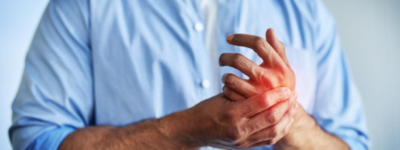 Man massaging numb hand due to burning or tingling discomfort