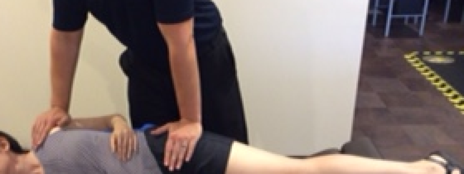 Chiropractor performing corrective chiropractic adjustment on patient's lower back during treatment