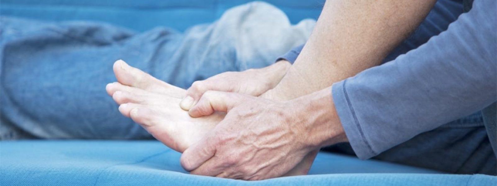 Woman massaging numb feet due to burning or tingling discomfort